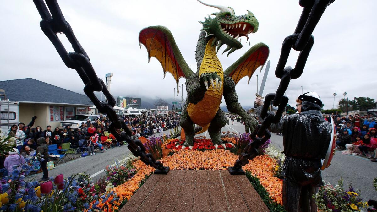 Lindsey Beckmeyer, dressed as a knight, faces a dragon while riding on the Rose Parade float from the city of Torrance on Monday. Beckmeyer came up with the design concept for the float.