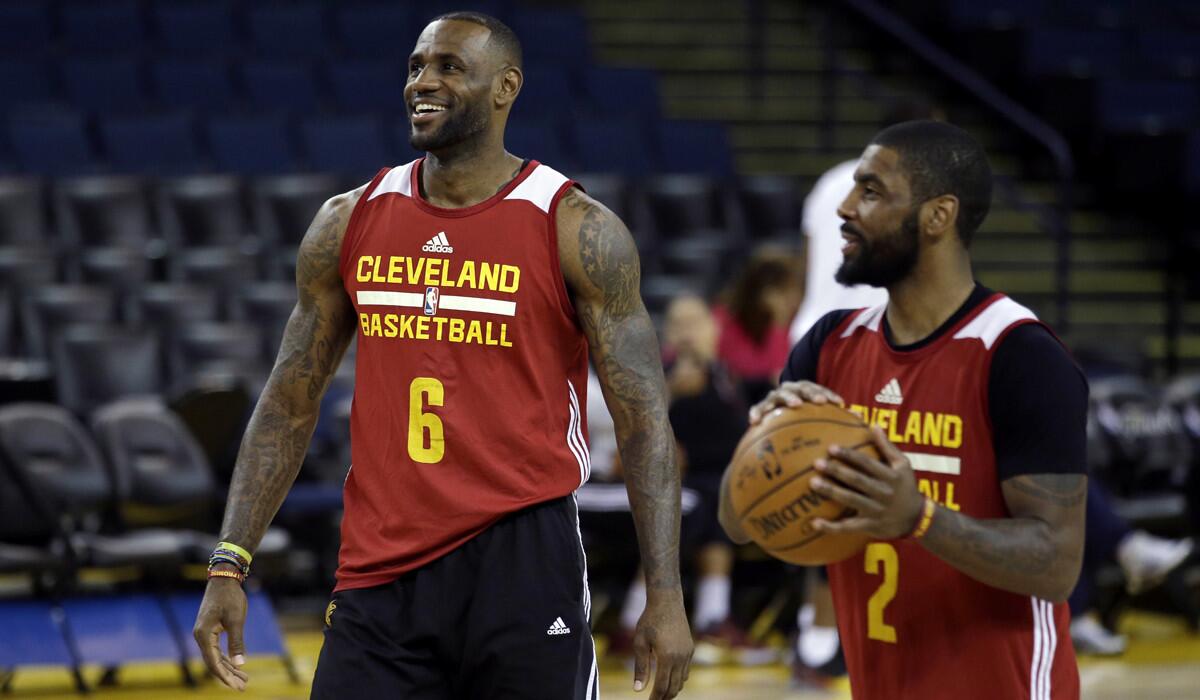 Cleveland Cavaliers' LeBron James, left, jokes with teammate Kyrie Irving during NBA practice on Wednesday.