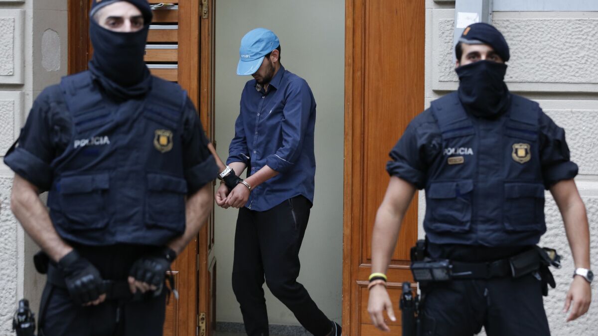 Catalan police officers detain a suspect in Ripoll during a search linked to the deadly terrorist attacks in Barcelona.