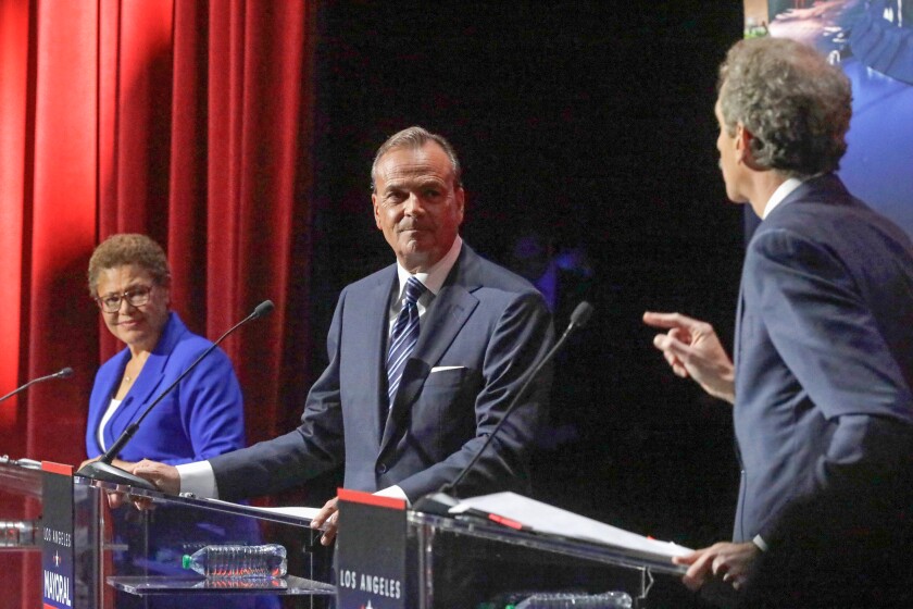 Los Angeles City Attorney Mike Feuer, right, responds to a pointed accusation made by businessman Rick Caruso