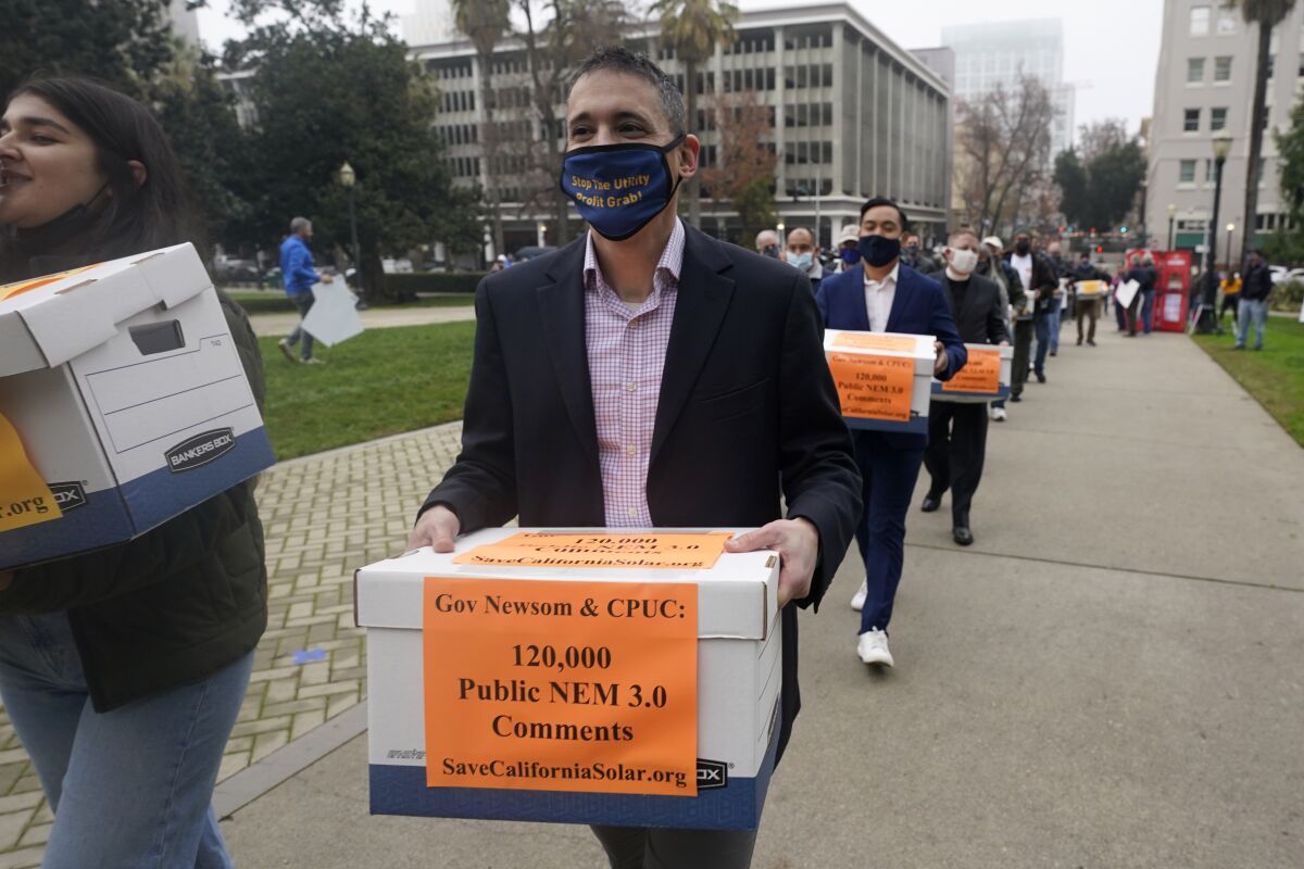 Solar energy advocates carry boxes of petitions  