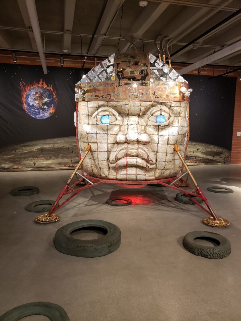 A sculpture of an Olmec head fused with a lunar landing vehicle.