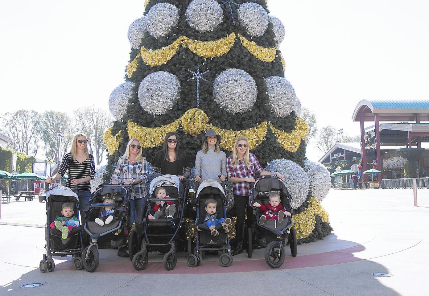 A group of mohters with their kids in strollers gather for picture at the central tree at the Winter Fest at the Orange County Fair and Events Center on Friday.