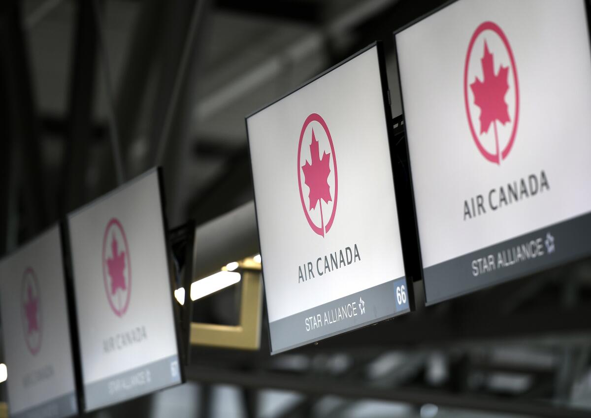 FILE - This May 16, 2020 file photo shows Air Canada check screens at Ottawa International Airport in Ottawa, Ontario, Canada. The U.S. government is seeking to fine Air Canada more than $25 million over what it says have been slow refunds for passengers whose flights were canceled since the pandemic started. The Transportation Department said Tuesday, June 15, 2021, it has received more than 6,000 consumer complaints about Air Canada since March of last year. (Justin Tang/The Canadian Press via AP)