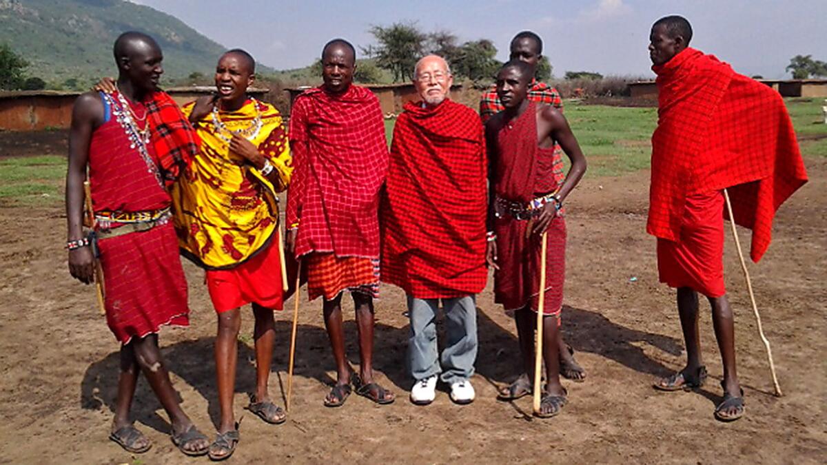 Unlike millennial backpackers, 76-year-old Hyo So is decidedly analog -- he scribbles notes on paper and commits things to memory rather than snap photos during his travels. Here he poses with Maasai tribesmen in Kenya.
