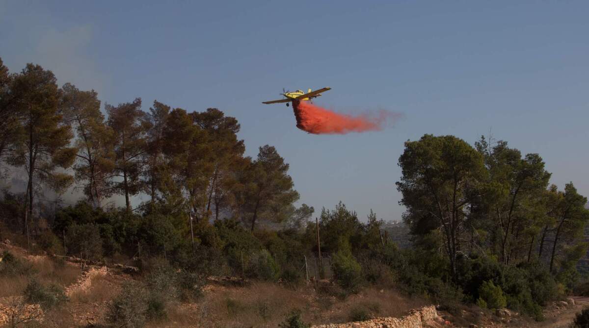An Israeli firefighting plane helps extinguish a fire over the Halamish settlement, northwest of Ramallah near the village of Nabi Saleh in the occupied West Bank.