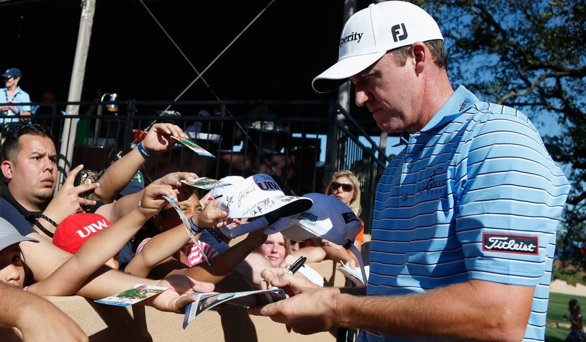 Jimmy Walker signs autographs for fans after finishing the third round of the Texas Open on Saturday.