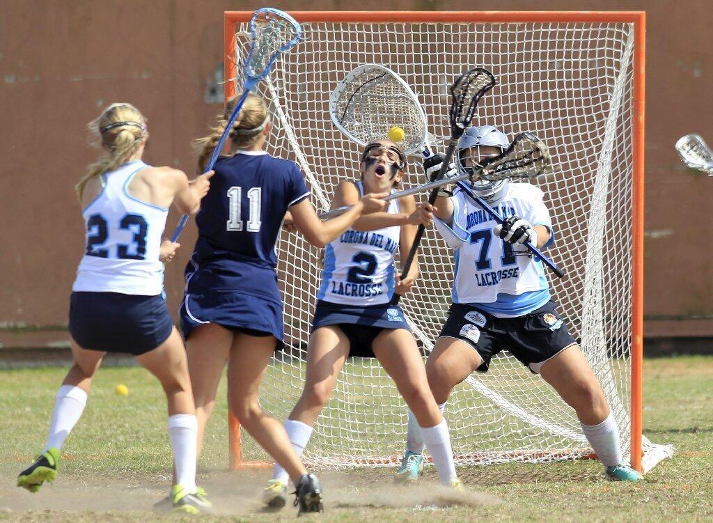 Corona del Mar High's Lindsie Hoffman (71), Megan Rieden (2) and Jensen Coop (23) crowd the net against Newport Harbor's Alex Palmer (11) during the Battle of the Bay game on Friday. Hoffman made the save on Palmer's shot.