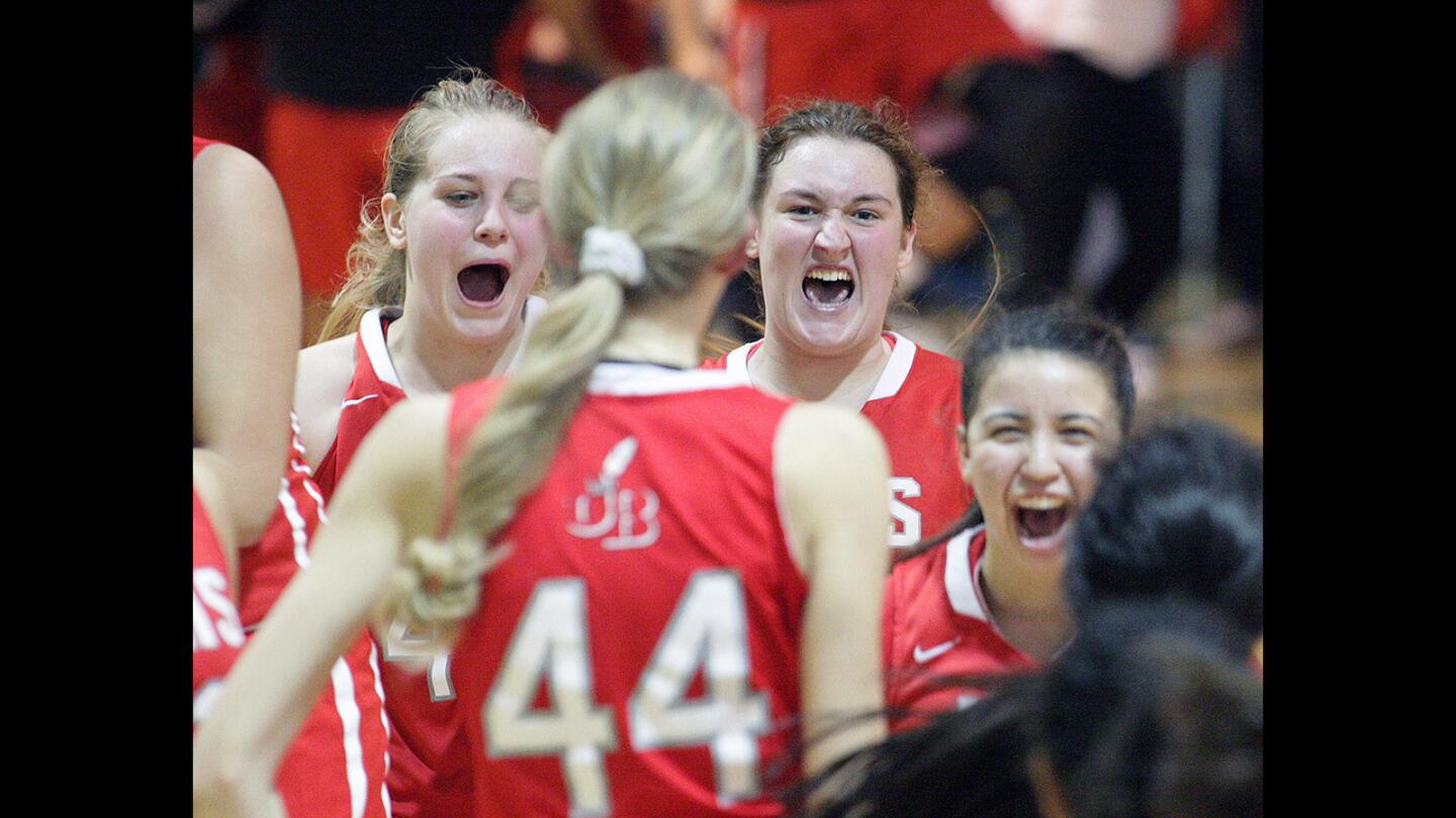 The Burroughs High girls' basketball ball team celebrates their win over rival Burbank High on Thursday, Jan. 22, 2016.