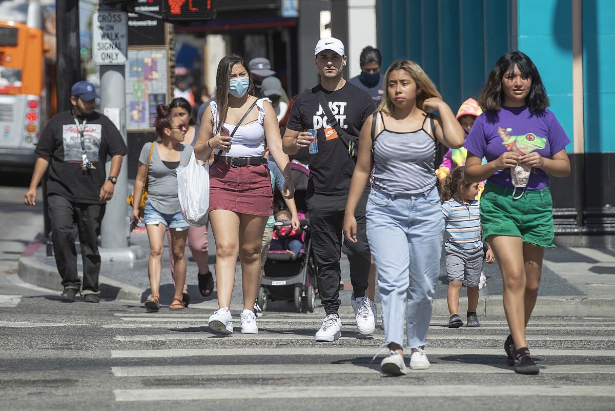 Masked and unmasked Californians crossing the street. 