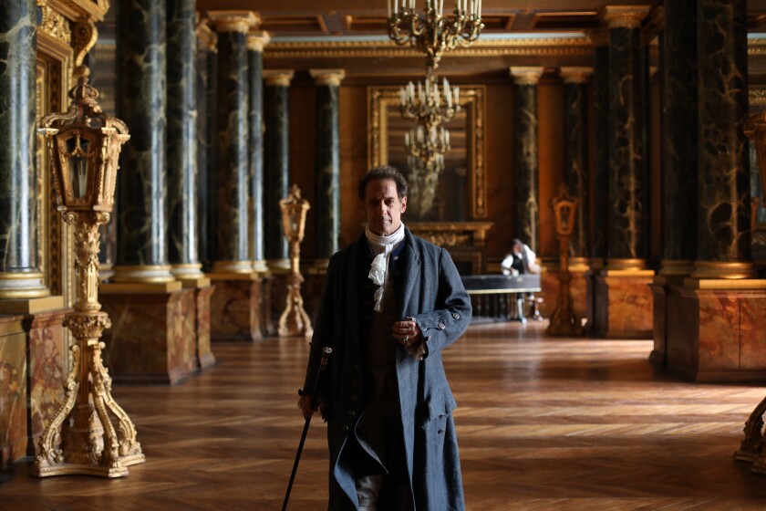 A well-dressed man walks through a luxurious 18th century hallway in the movie “Casanova, Last Love.”