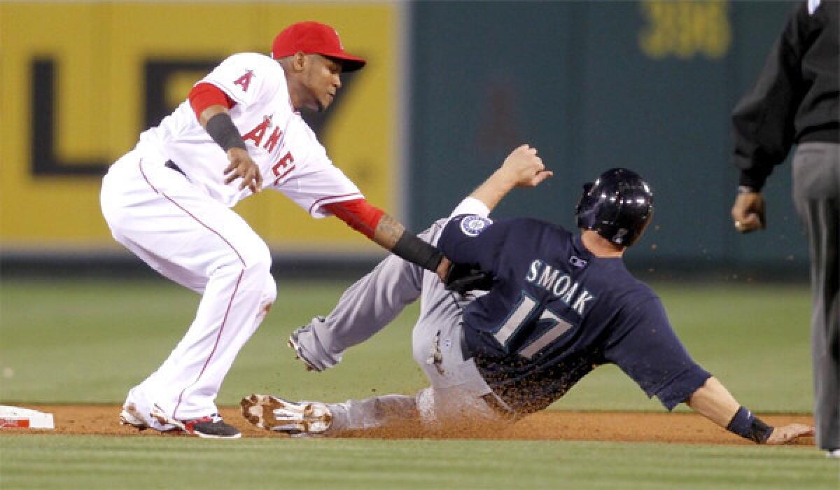 Erick Aybar tags the Mariners' Justin Smoak out at second base during the second inning of the Angels' 8-3 loss at Angels Stadium