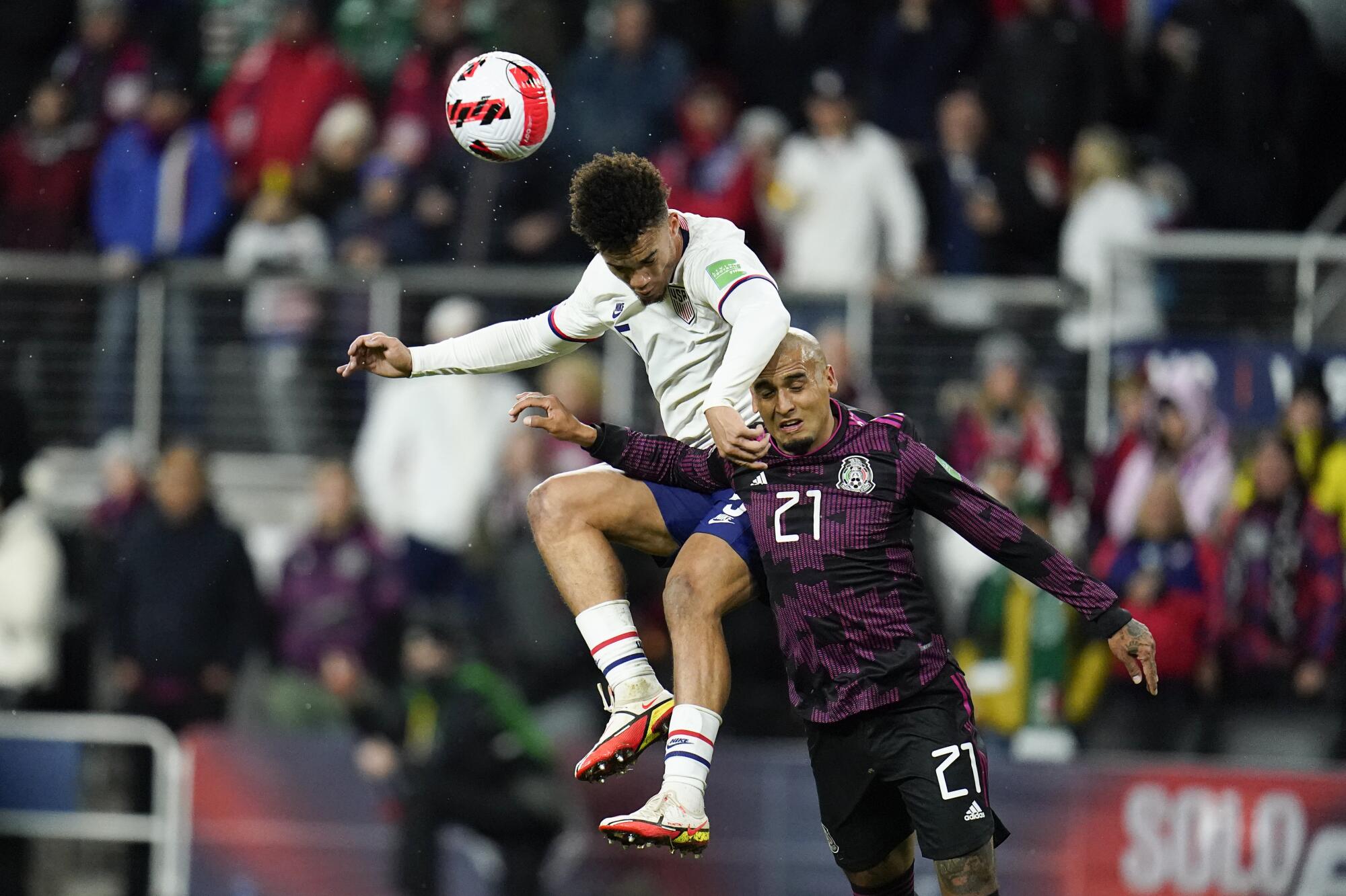United States' Antonee Robinson, left, goes up for the ball against Mexico's Luis Rodriguez.