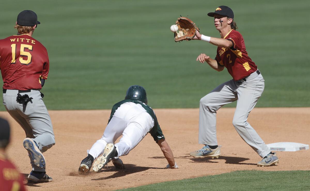 Costa Mesa's Chris Hall is stuck in a rundown between Estancia's Riley Witte (15) and Andrew Mits (2) during Monday's game.