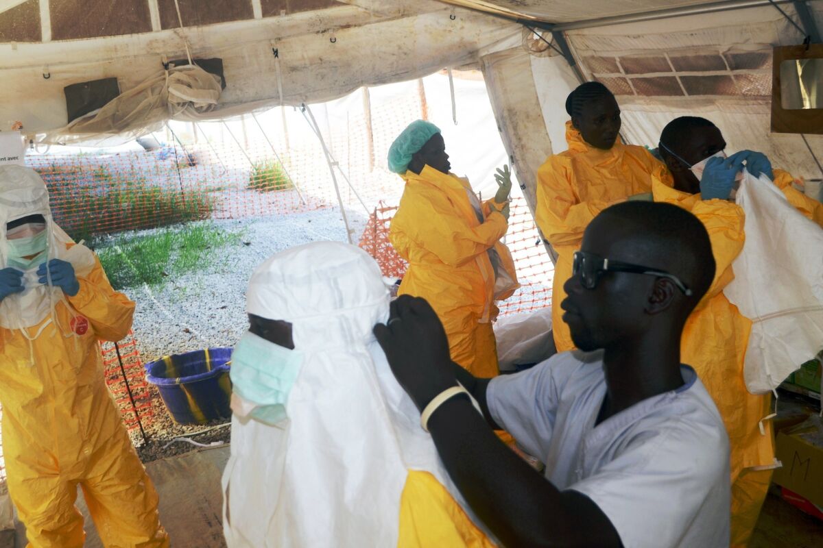 Members of Doctors Without Borders put on protective gear at the isolation ward of the Donka Hospital in Conakry, Guinea, where people infected with the Ebola virus are treated.