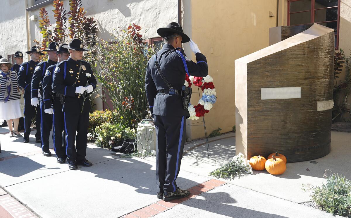 Laguna Beach Police Department officers and color guard salute the fallen officers memorial during the remembrance ceremony. 
