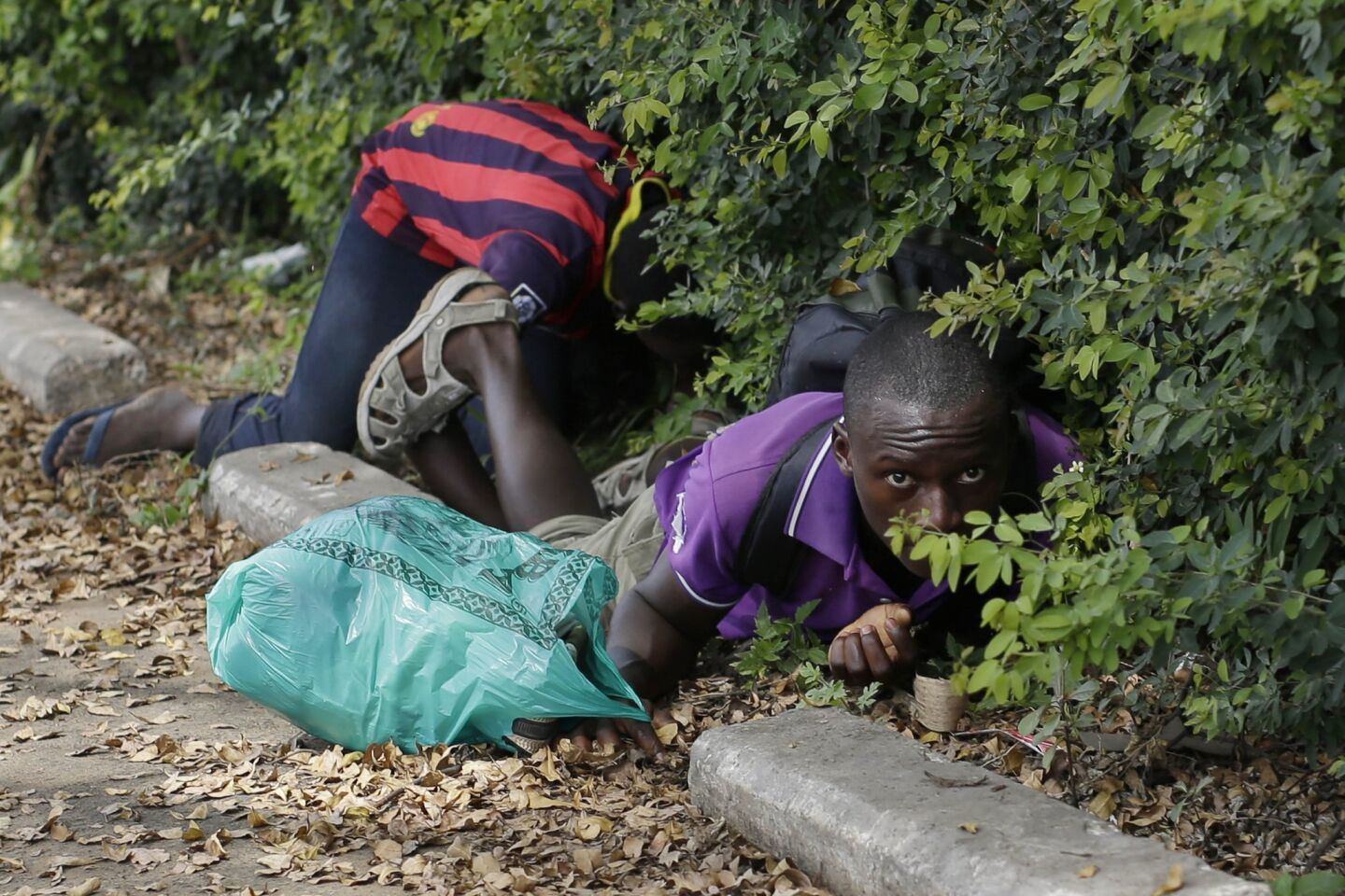 Men duck for cover as shots are fired May 4 in Bujumbura.