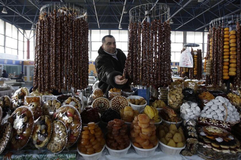 **ADVANCE FOR SATURDAY, JUNE 7** A man displaying traditional Armenian dried fruit and sweets at a market in Yerevan, Armenia, Thursday, Feb. 21, 2008. Officials say Armenians are no longer fleeing their motherland and some of the diaspora are even choosing to return. (AP Photo/Misha Japaridze)