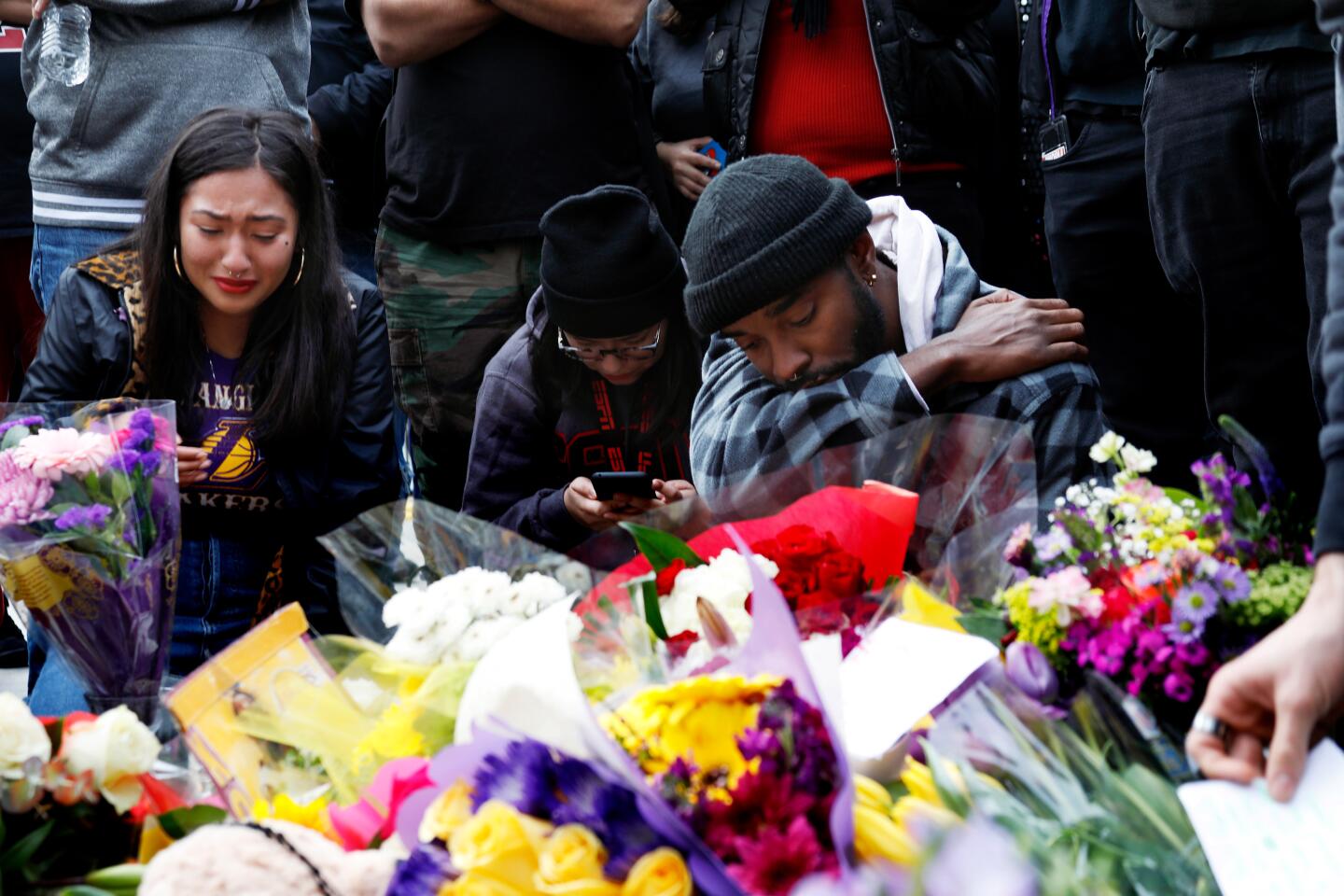 Fans gather near a makeshift memorial for Kobe Bryant outside Staples Center after learning of the Lakers legend's death Sunday.