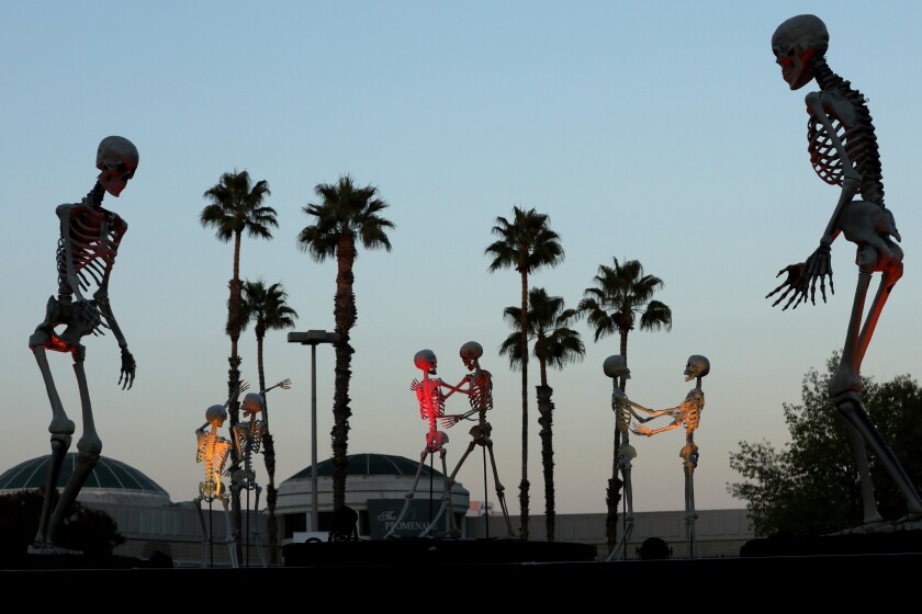 WOODLAND HILLS, CA - OCTOBER 19: Dancing skeletons at Hauntoween LA in Woodland Hills which provides a drive-through Halloween experience during this pandemic era. There is an ongoing conversation about the effects of being alone in covid, with the twist that now that we're figuring out how to live with covid, we're still struggling with what happens to those who are alone. Photograhed at Hauntoween LA on Monday, Oct. 19, 2020 in Woodland Hills, CA. (Myung J. Chun / Los Angeles Times)