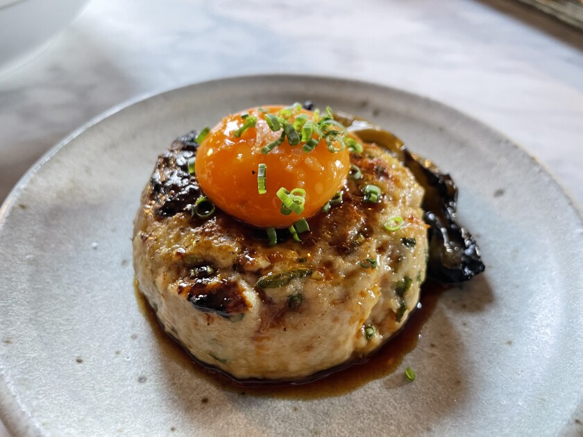 Tsukune topped with an egg yolk and scallions