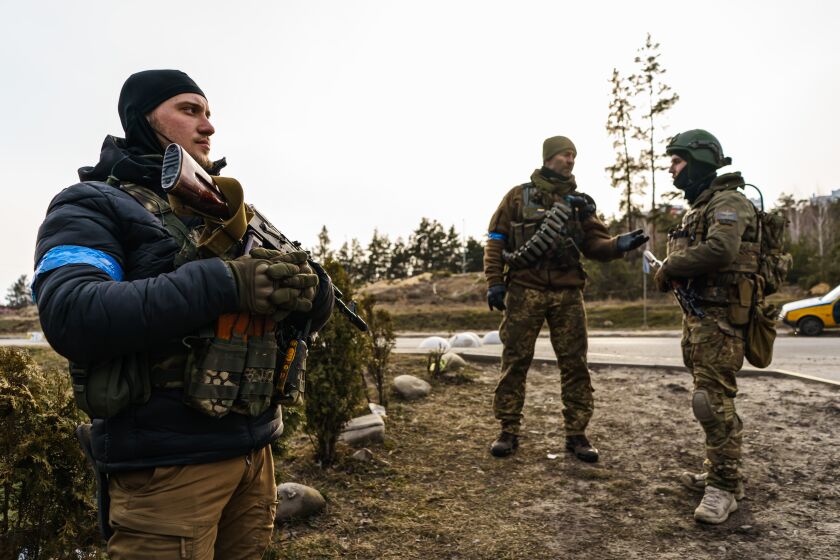 IRPIN, UKRAINE -- MARCH 12, 2022: Ukrainian soldiers stand ready at a checkpoint in Irpin, Ukraine, Saturday, March 12, 2022. (MARCUS YAM / LOS ANGELES TIMES)
