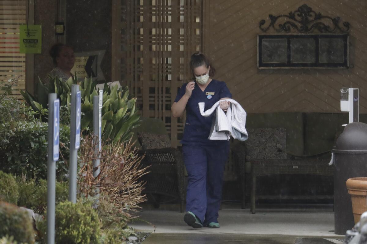 A worker at the Life Care Center in Kirkland, Wash., where the COVID-19 death toll reached 19 on Monday.