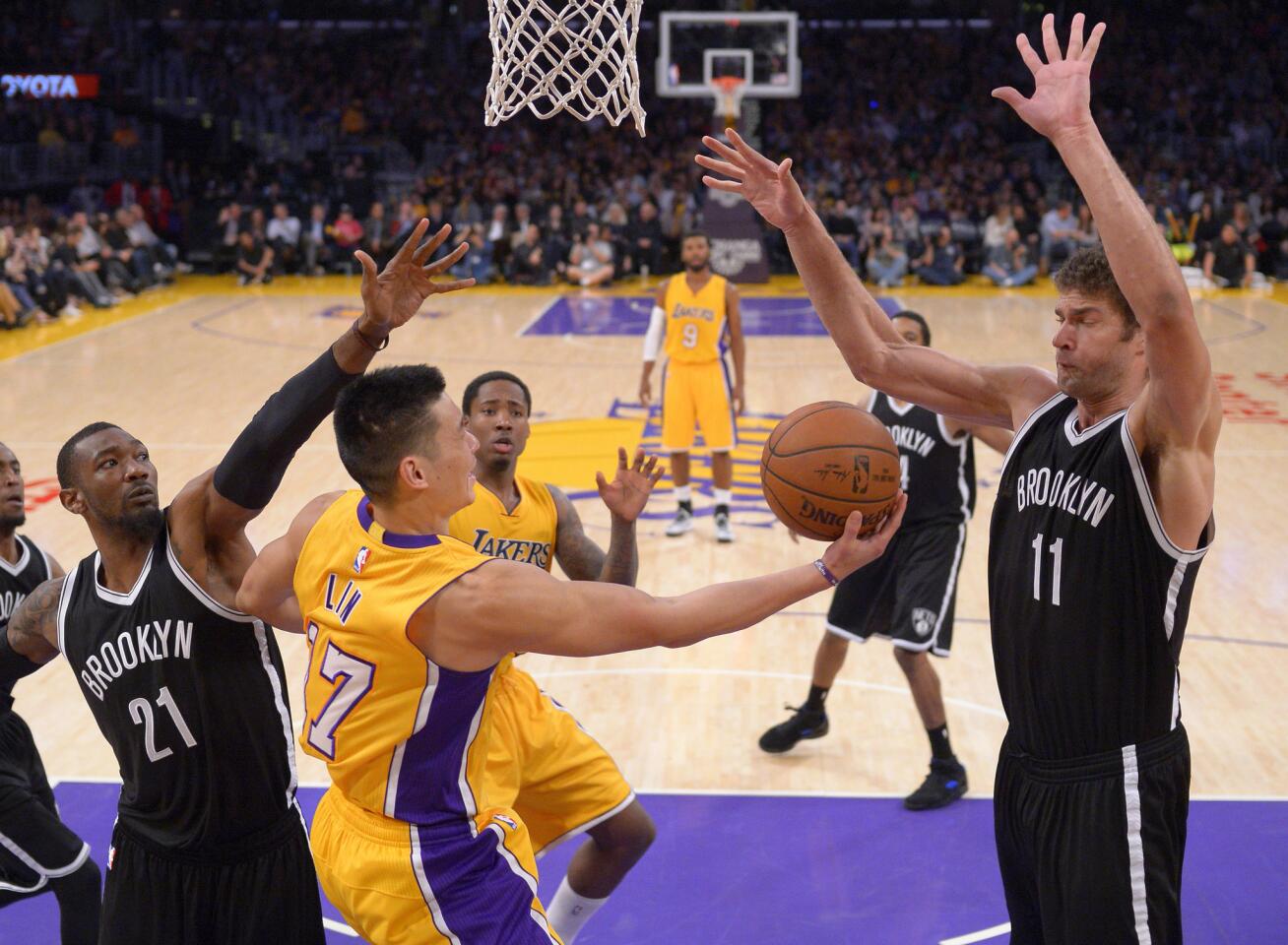 Lakers point guard Jeremy Lin attempts a reverse layup against the Nets' Cory Jefferson (21) and Brook Lopez (11) at Staples Center.
