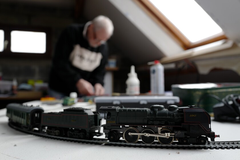 Guy Warein, a 70-year-old retiree, works on model trains in his home in Richebourg, northern France, Wednesday, Jan 27, 2021. The old-school pastimes of making scale models and playing with miniature trains are making a comeback as a form of therapy against the pandemic blues. Sales are booming as locked-down families glue and paint models and dust off train sets. (AP Photo/Michel Spingler)