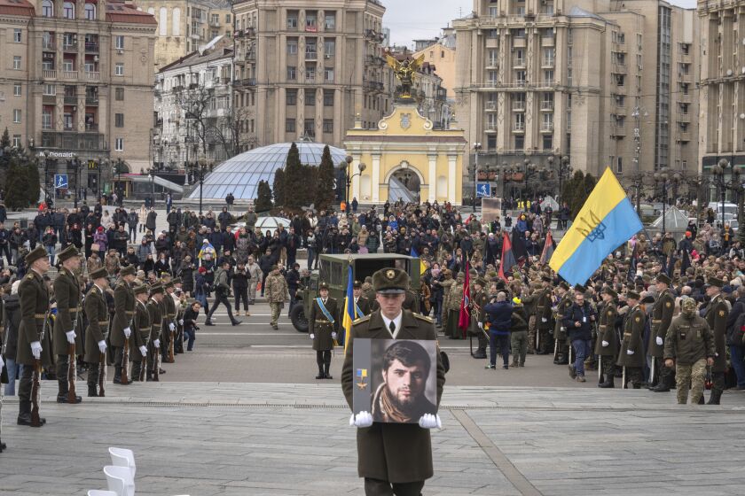 A serviceman carry a photo of Ukrainian officer Dmytro Kotsiubaylo, code-named "Da Vinci", during a commemoration ceremony in Independence Square in Kyiv, Ukraine, Friday, March 10, 2023. Kotsiubaylo was killed three days ago in a battle near Bakhmut in the Donetsk region. (AP Photo/Efrem Lukatsky)