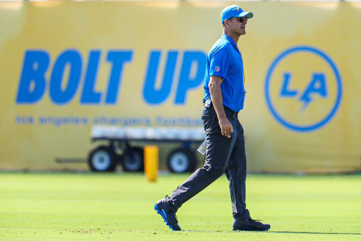 Chargers coach Jim Harbaugh walks across the field during a training camp workout in El Segundo Wednesday. 