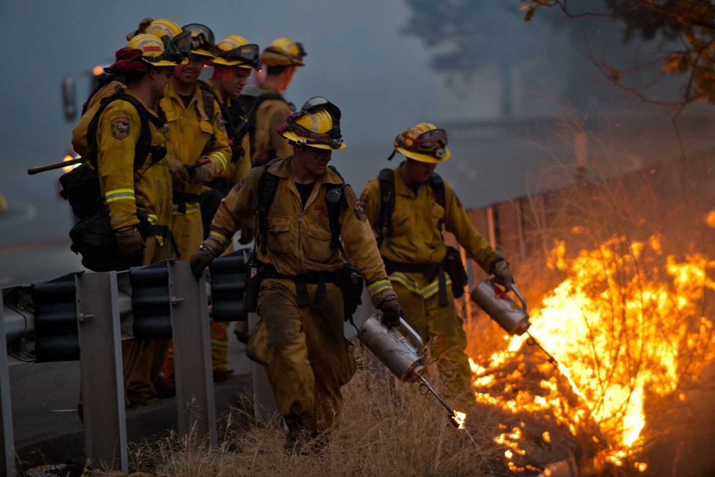 A crew burns away dry brush along U.S. Highay 50 near Pollock Pines, Calif.