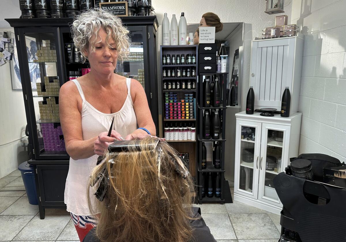 Christine Geiger cuts a customer's hair at her salon.