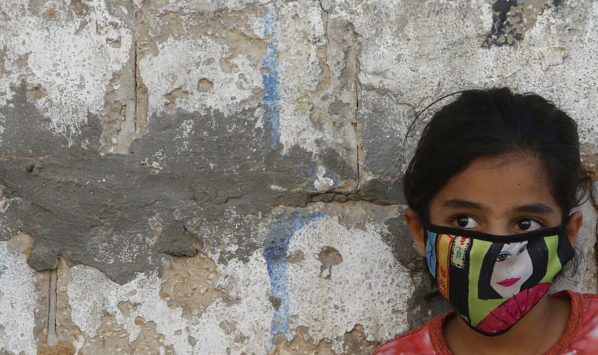 A Palestinian girl wears a face mask in the Gaza Strip