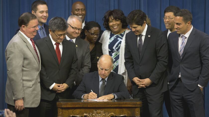 California Gov. Jerry Brown signs legislation in 2016 creating CalSavers, a retirement savings program for workers whose employers don't offer a pension or 401(k). An anti-tax group is suing the state over the program.