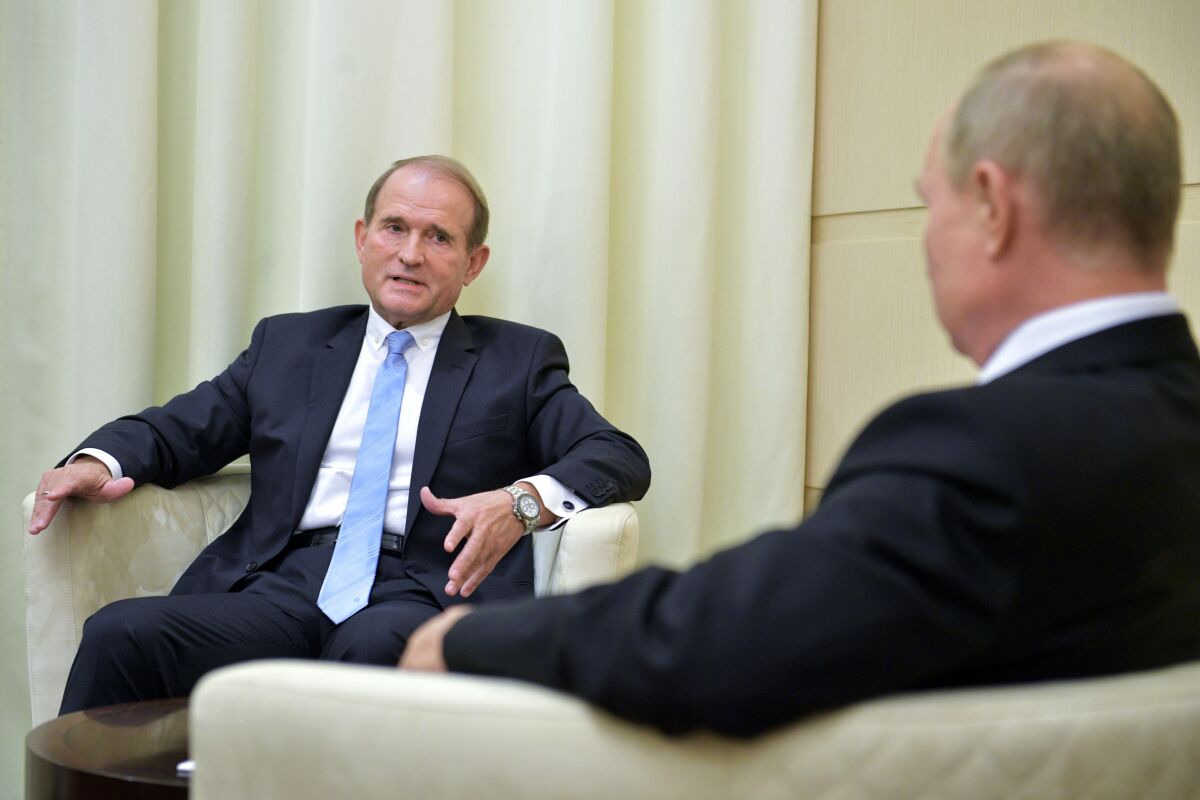 Ukrainian tycoon Viktor Medvedchuk, left, speaks to Russian President Vladimir Putin during a meeting at the Novo-Ogaryovo residence outside Moscow, Russia, Tuesday, Oct. 6, 2020. Medvedchuk, who heads the Opposition Platform for Life party and has close ties with Putin, was placed under house arrest on Thursday, May 13, 2021 by a Ukrainian court on treason charges that he denied. (Sputnik, Kremlin Pool Photo via AP)