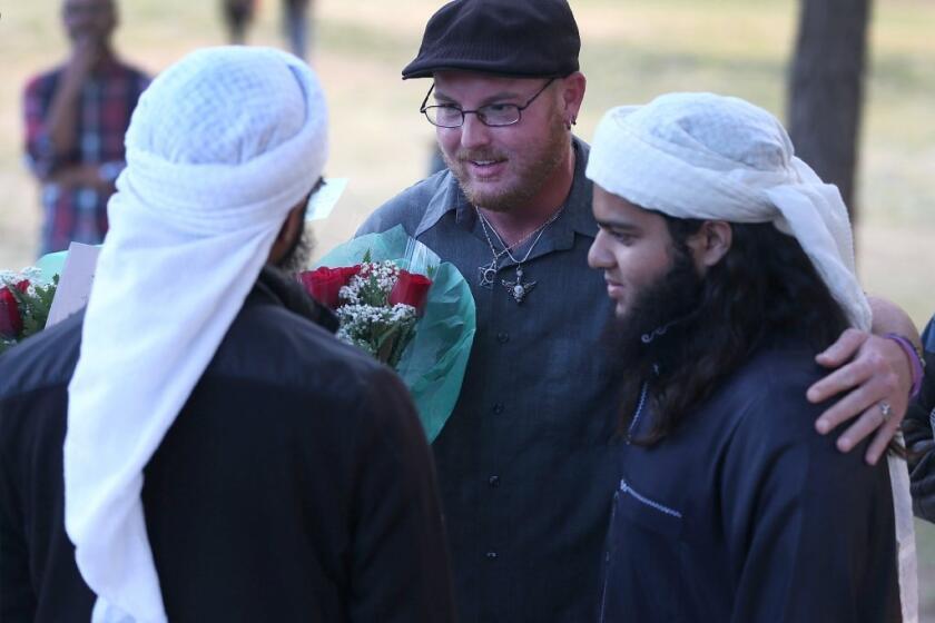 Ryan Reyes, center, speaks with Nizaam Ali, left, and Rahemaan Ali, who came to pay their respects during a memorial service for Ryan's boyfriend, Daniel Kaufman, who was killed in the mass shooting last month at the Inland Regional Center in San Bernardino.