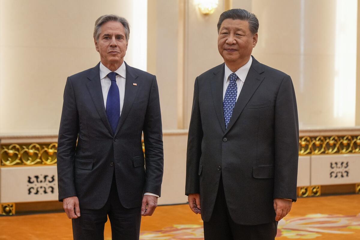 Secretary of State Antony Blinken stands with Chinese President Xi Jinping.