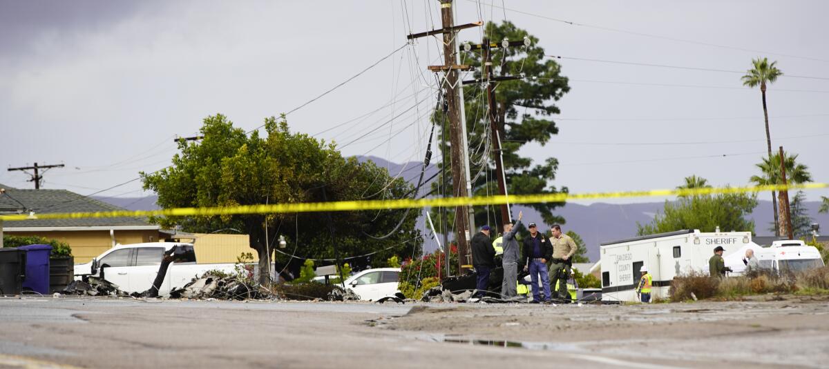 Crime scene tape blocks off an area with debris from a plane crash