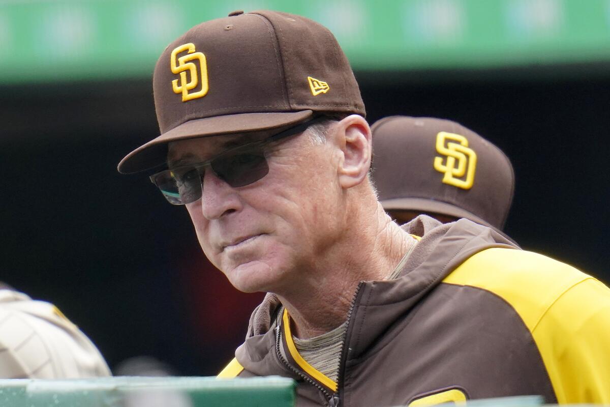Padres manager Bob Melvin wearing sunglasses while standing in the dugout during a game against the Pirates.