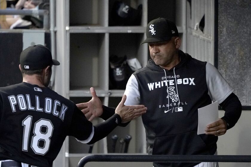 Chicago White Sox bench coach Miguel Cairo greets AJ Pollock after the White Sox announced that Cairo would manage the team in the absence of manager Tony La Russa, who will undergo further medical testing at the direction of his doctors with an undisclosed illness, before a baseball game against the Kansas City Royals on Tuesday, Aug. 30, 2022, in Chicago. (AP Photo/Charles Rex Arbogast)