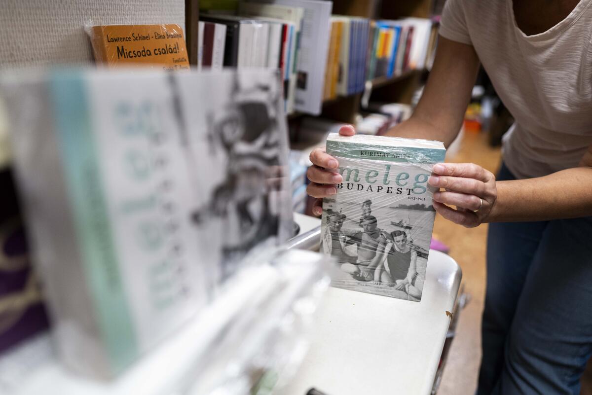 An employee of a bookstore wraps a book featuring LGBTQ+ content in closed packaging in Budapest, Hungary. 