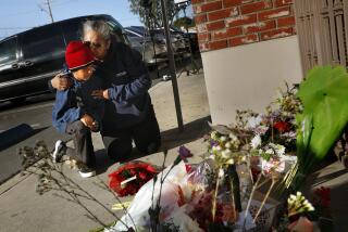 MONTEREY PARK, LOS ANGELES, CALIFORNIA-Jan. 23, 2023-At the scene where 11 people were killed in a mass shooting in Monterey Park, California at the Star Dance Studio, Inez Arakaki, right, hugs her son, Zachary Arakaki, age 9, after they place red roses at the scene in honor of the victims. Inez Arakaki, a school bus driver from Alhambra, came to drop off flowers at the dance studio with her son Zachary Arakaki, age 9. "It's heartbreaking," says Inez. "How do you explain it to your children? I had to come here. The evil that's here. It's supposed to be a joyous time. This should not be happening." (Carolyn Cole / Los Angeles Times)