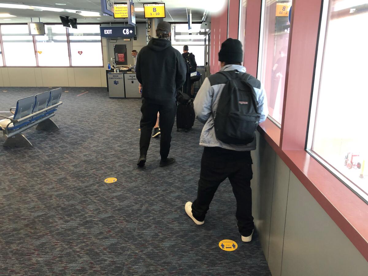 Passengers stand by distanced dots in line for a Southwest flight at the Las Vegas airport in early June.
