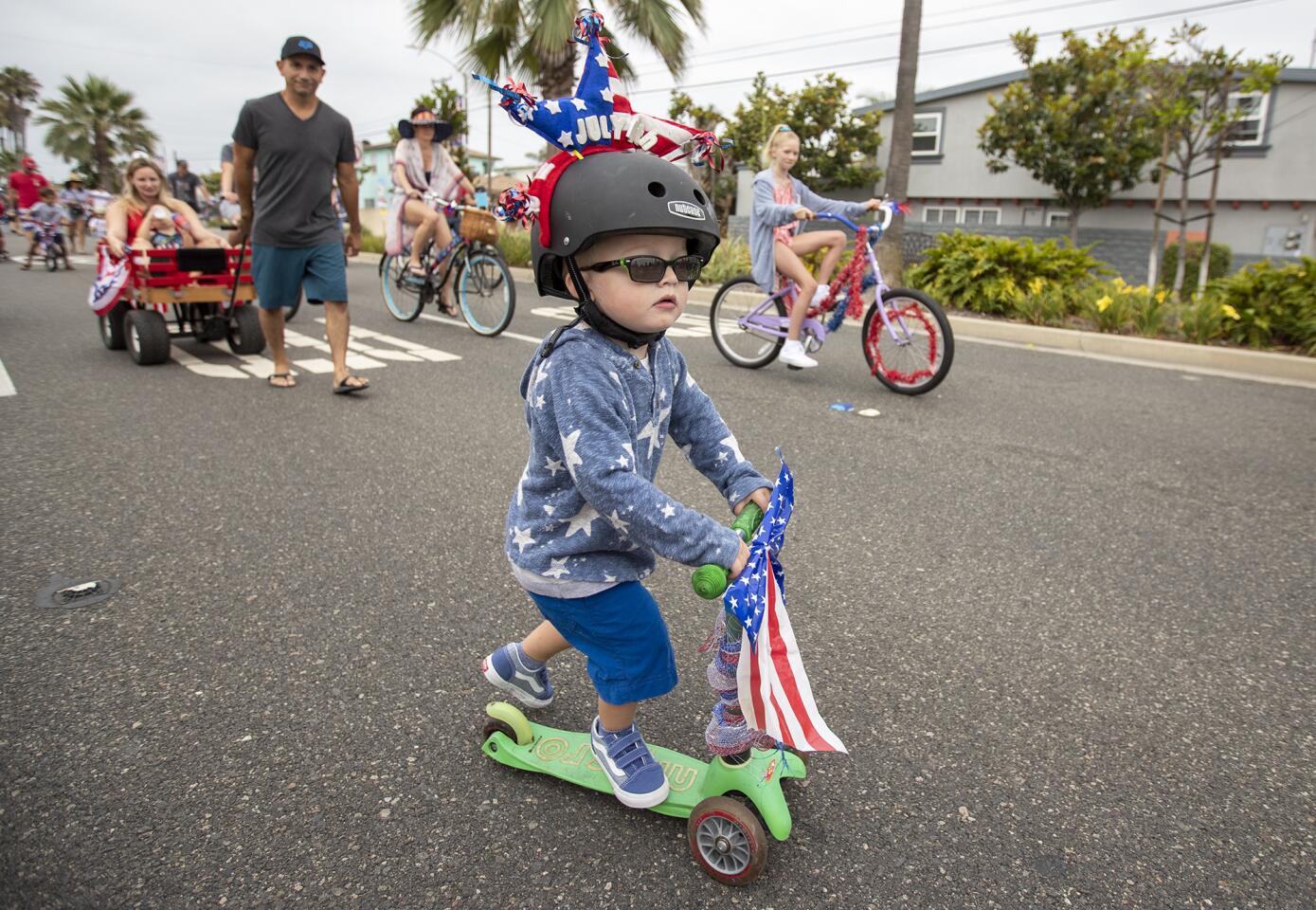 Van Newton, 2, rides his deorated scooter along Balboa Boulevard during the annual Newport Peninsula Bike Parade on Thursday, July 4.