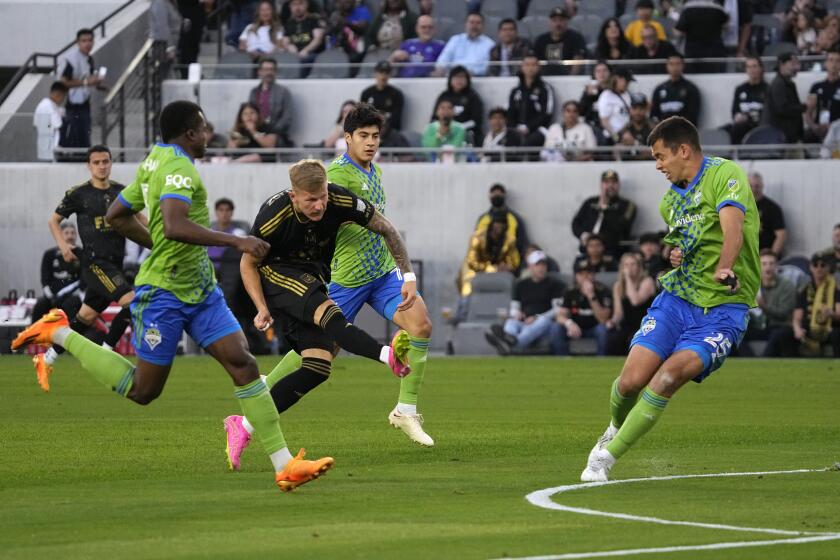 Los Angeles FC midfielder Mateusz Bogusz, second from left, scores while under pressure from Seattle Sounders defender Nouhou Tolo, left, midfielder Obed Vargas, second from right, and defender Jackson Ragen during the first half of a Major League Soccer match Wednesday, June 21, 2023, in Los Angeles. (AP Photo/Mark J. Terrill)