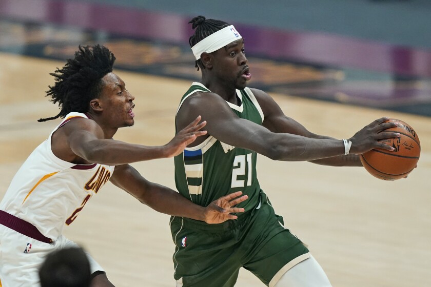 Milwaukee Bucks' Jrue Holiday (21) drives against Cleveland Cavaliers' Collin Sexton (2) in the first half of an NBA basketball game, Saturday, Feb. 6, 2021, in Cleveland. (AP Photo/Tony Dejak)