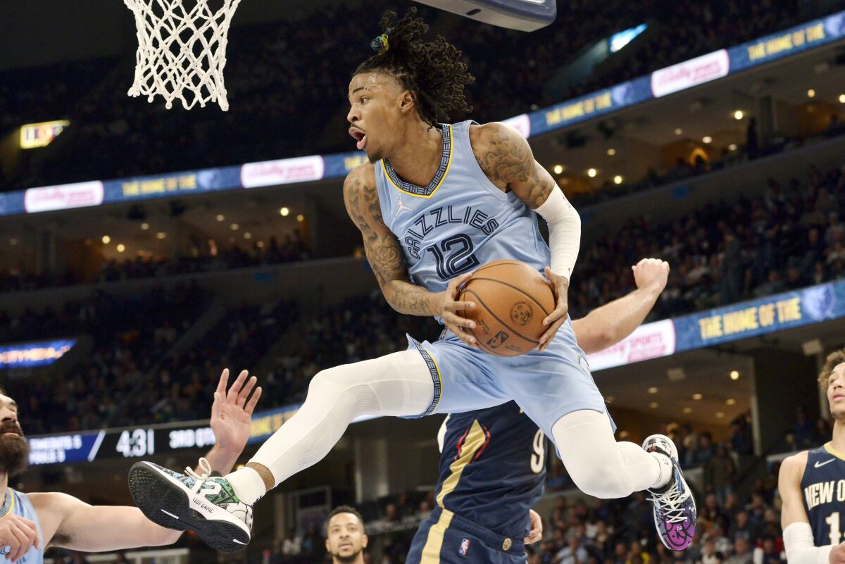 Memphis Grizzlies guard Ja Morant (12) handles the ball under the basket during the second half of the team's NBA basketball game against the New Orleans Pelicans onSaturday, April 9, 2022, in Memphis, Tenn. (AP Photo/Brandon Dill)