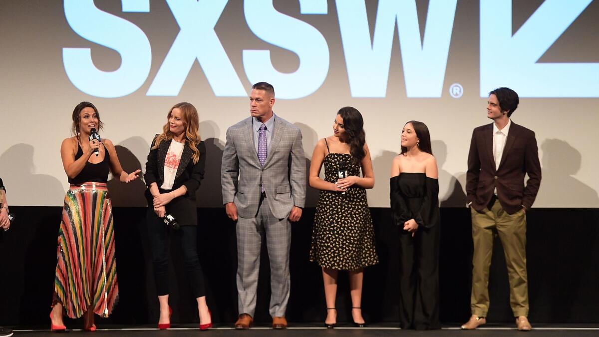 Kay Cannon speaks at the SXSW "Blockers" premiere at the Paramount in Austin, Texas, with, from left, Leslie Mann, John Cena, Geraldine Viswanathan, Gideon Adlon and Miles Robbins.