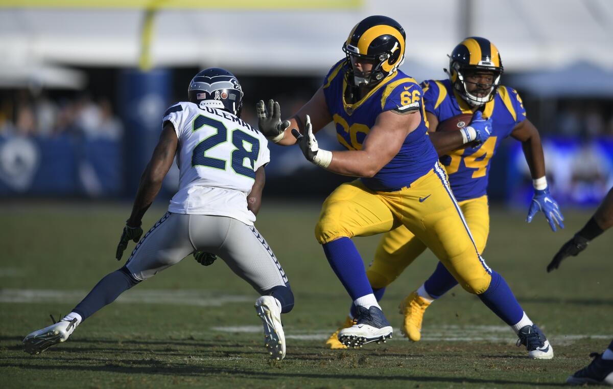 Rams offensive lineman Austin Blythe (66) blocks Seattle's Justin Coleman to allow Malcolm Brown (34) room to run Nov. 11, 2018, at the Coliseum.